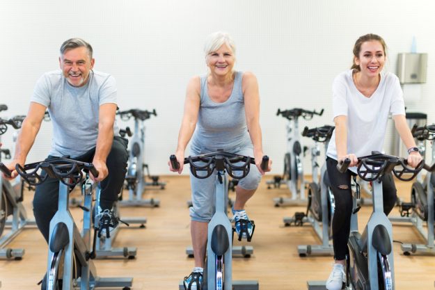 Confident seniors on exercise bikes in spinning class at gym 3 Benefits Of Maintenance-Free Lifestyle When Moving Into Independent Living
