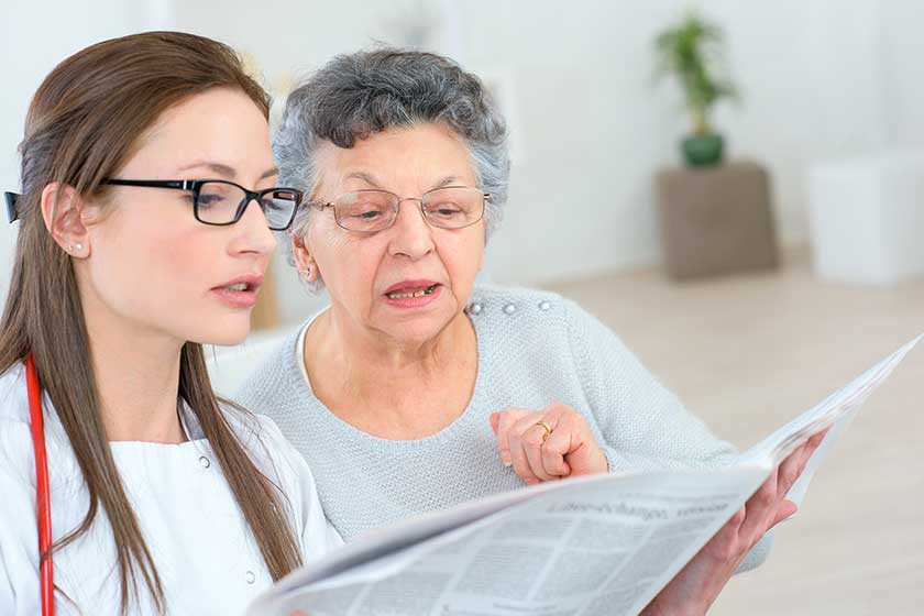Doctor helping a patient to read Doctor helping a patient to read