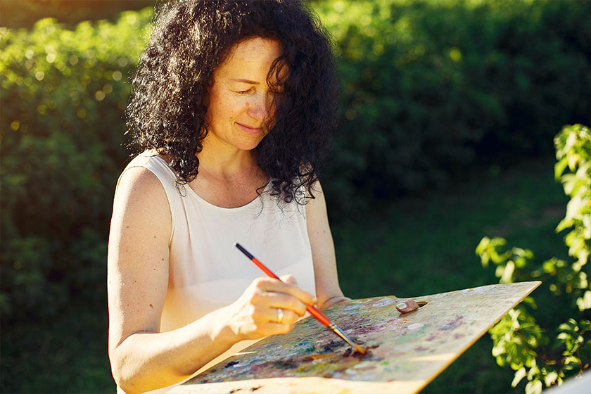 Beautiful adult woman drawing in a summer field Beautiful adult woman drawing in a summer field