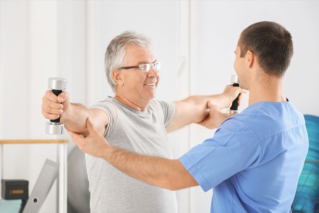 Physiotherapist working with senior patient in modern clinic Physiotherapist working with senior patient in modern clinic