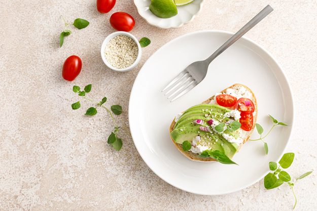 Avocado toast with cheese cottage, tomato and herbs for breakfast Avocado toast with cheese cottage, tomato and herbs for breakfast