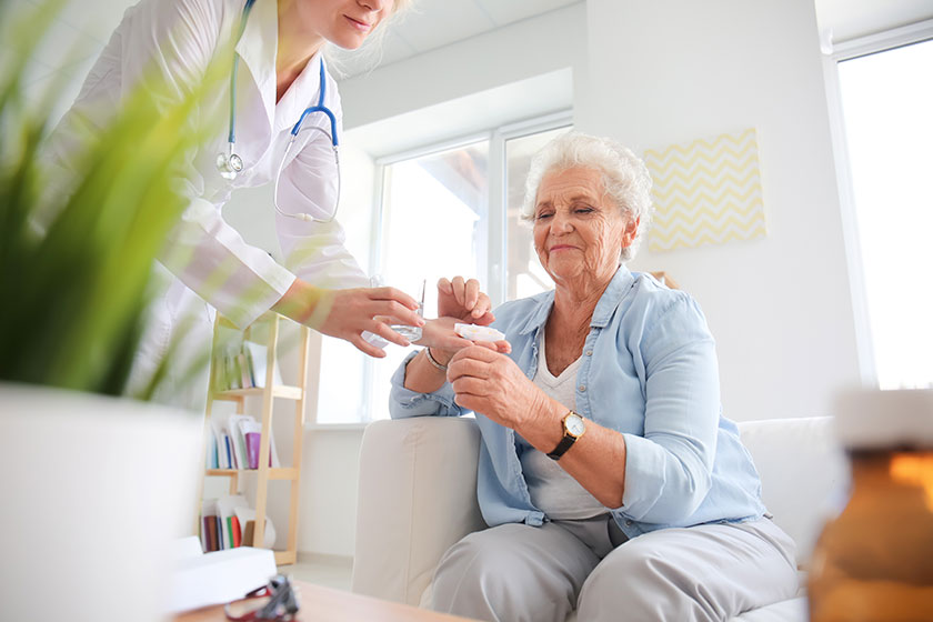 Doctor giving medicine to senior woman at home Doctor giving medicine to senior woman at home