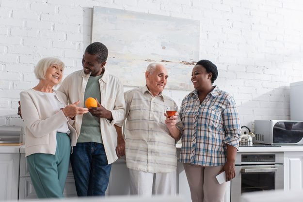 Positive-interracial-senior-people-tea-fruit-smartphone-talking-nursing-home Positive-interracial-senior-people-tea-fruit-smartphone-talking-nursing-home