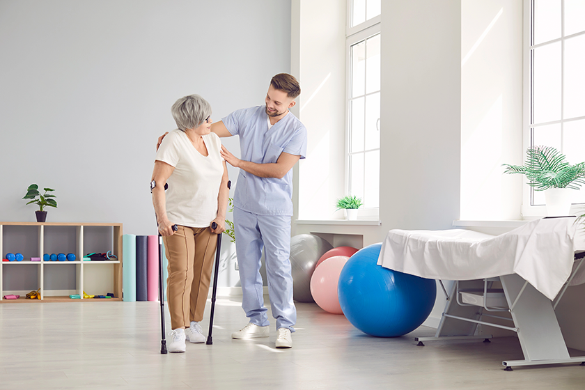 young-male-caregiver-nurse-helping-disabled-aged-female-patient young-male-caregiver-nurse-helping-disabled-aged-female-patient