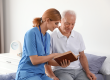 Nurse reading book to elderly man