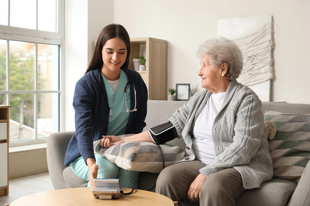 Young caregiver measuring blood pressure