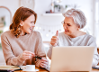 Young daughter smiling and looking to elderly lady