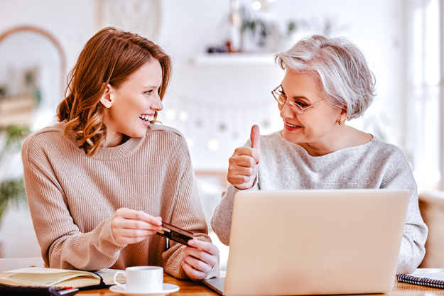 young-daughter-smiling-looking-elderly-lady Young daughter smiling and looking to elderly lady
