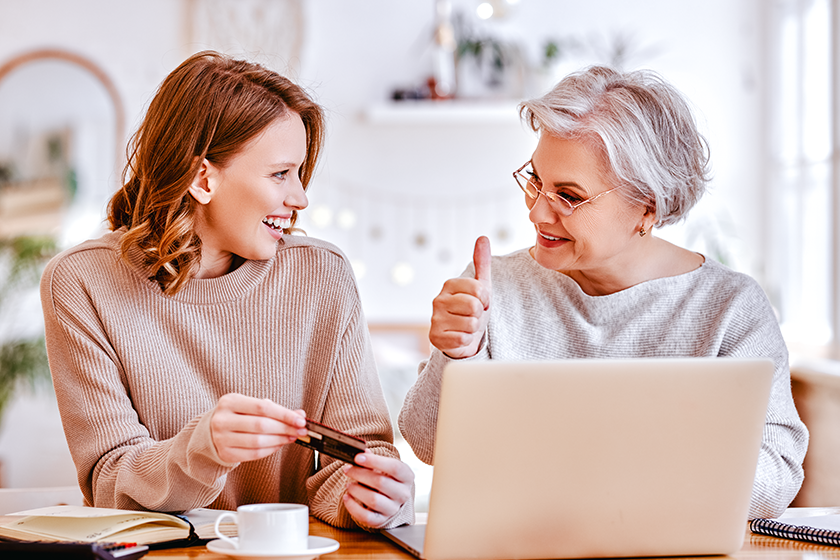 Young daughter smiling and looking to elderly lady